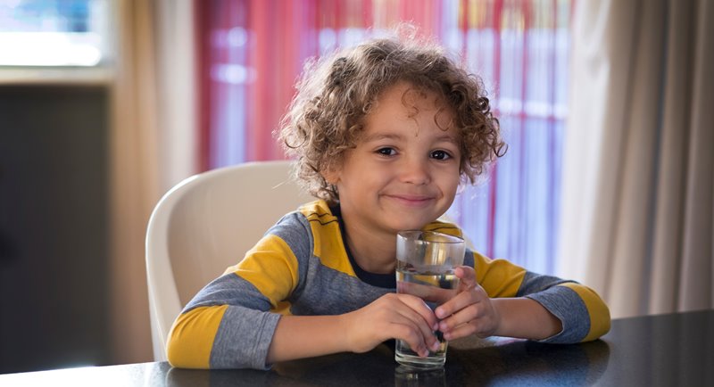 Photo of a boy holding a glass of water